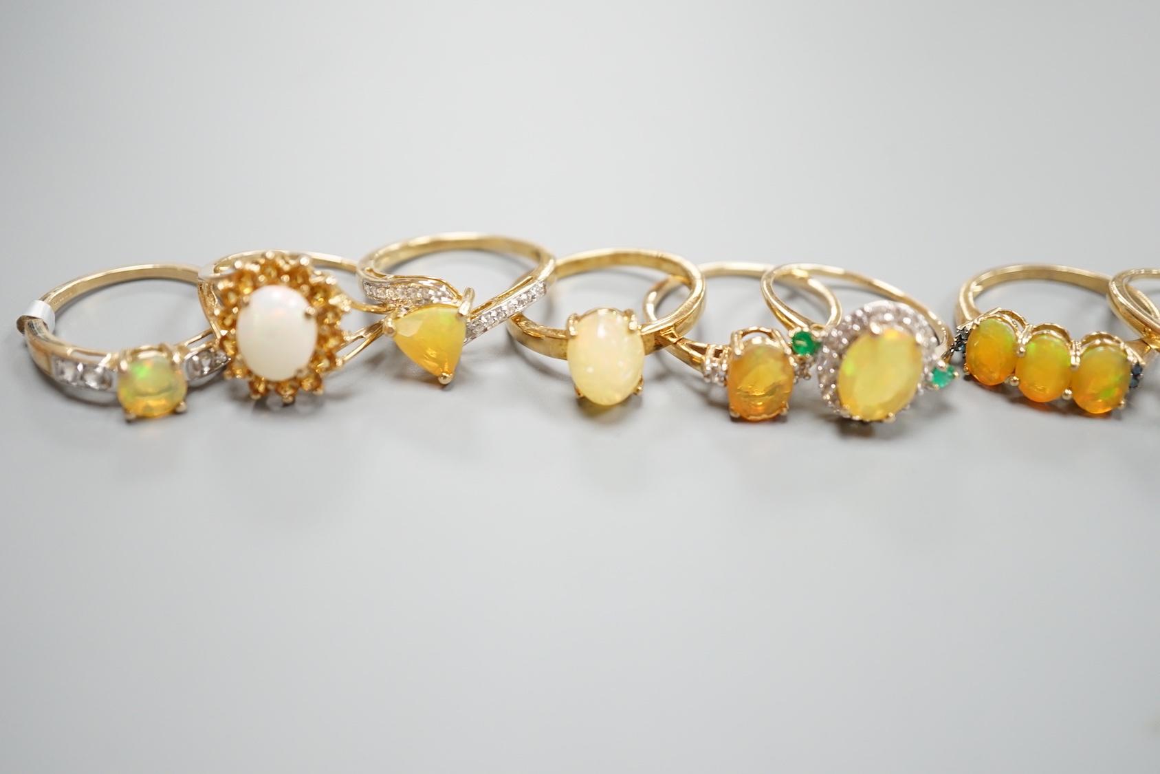 Seven assorted modern 9ct gold, opal and gem set dress rings, gross 14.6 grams and a 925 ring.